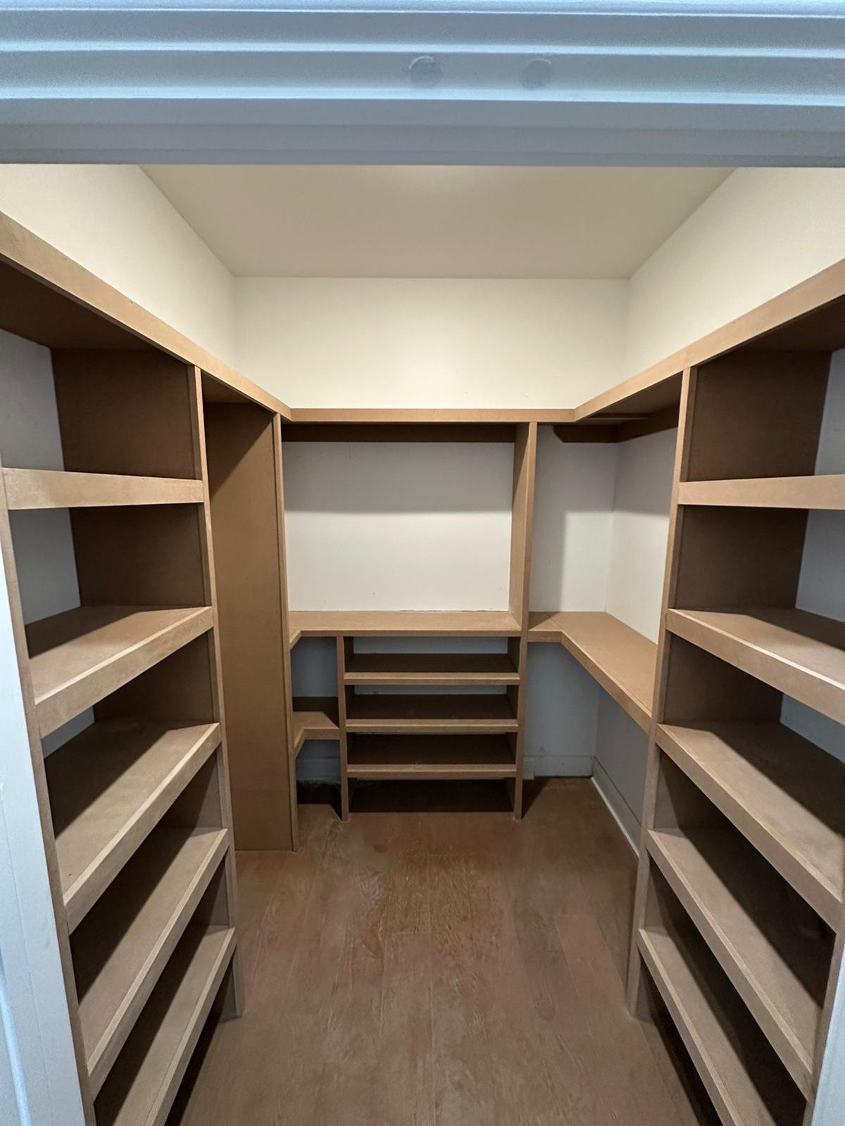 Finished walk-in closet with custom shelving and built-in storage