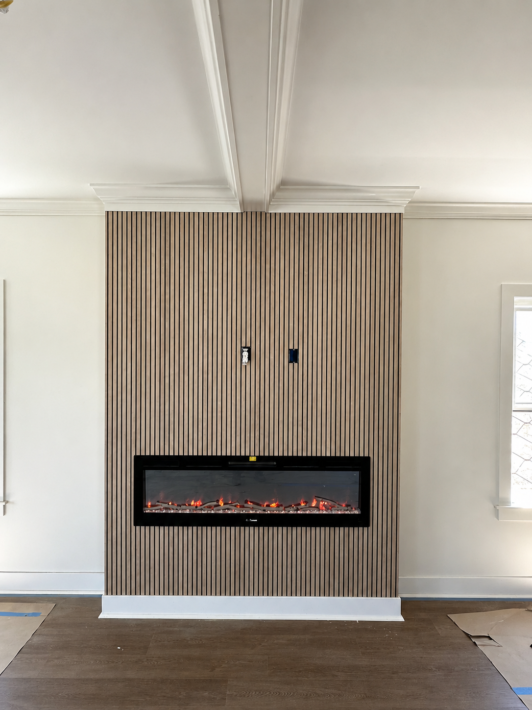 Finished fireplace wall with vertical wood slats and built-in electric fireplace