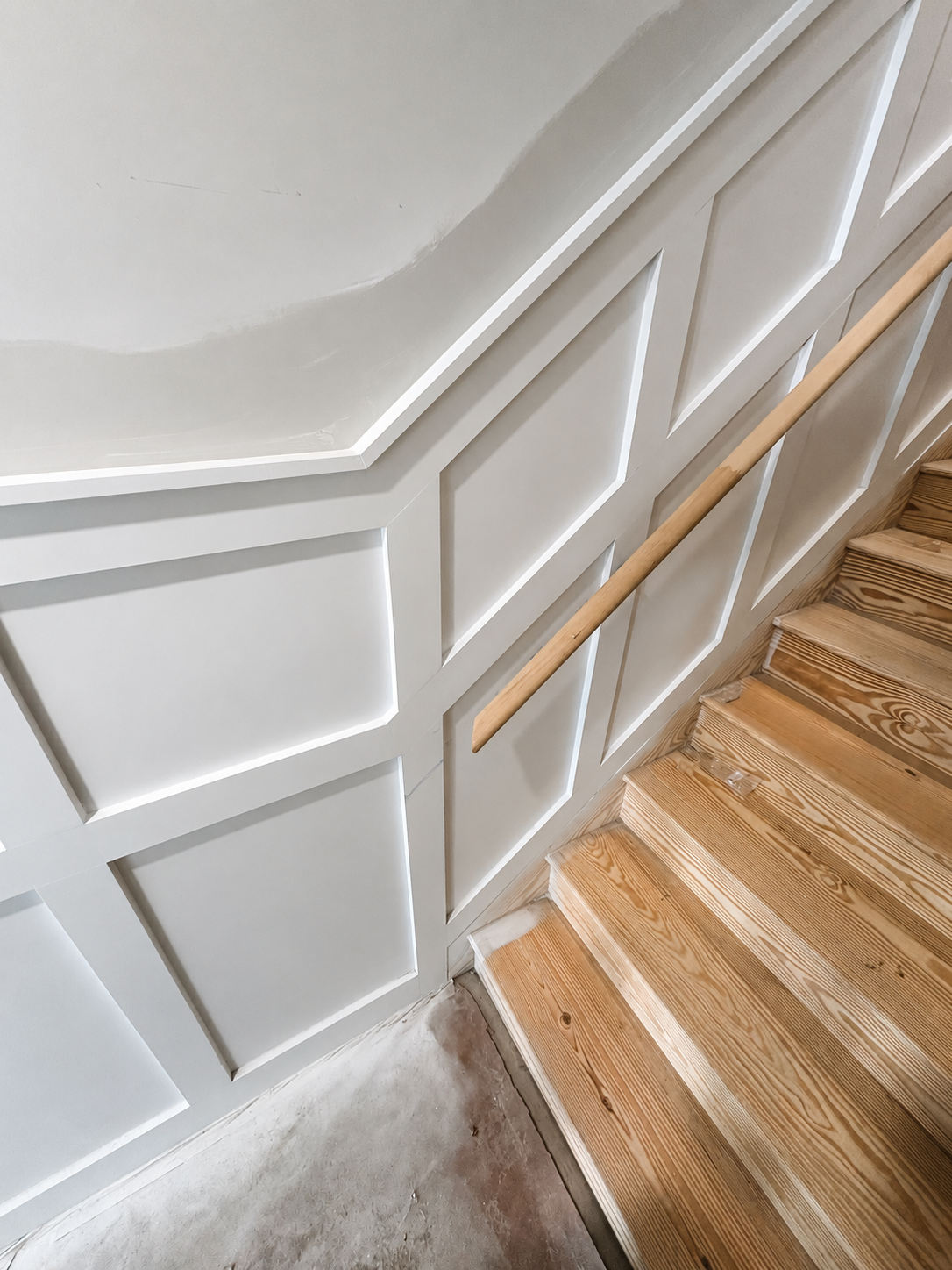 Close view of completed staircase wall paneling and trim