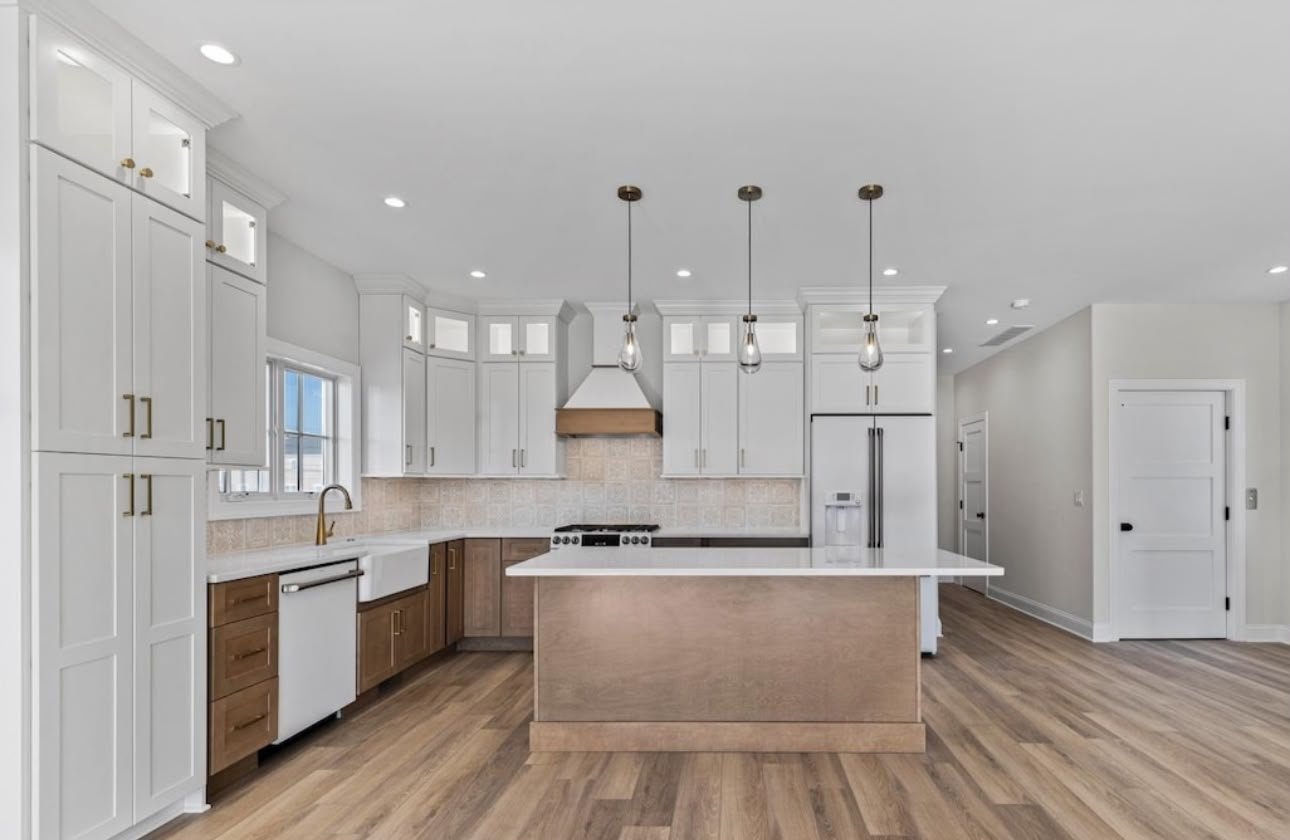 Finished custom kitchen cabinetry with a navy island and white cabinets