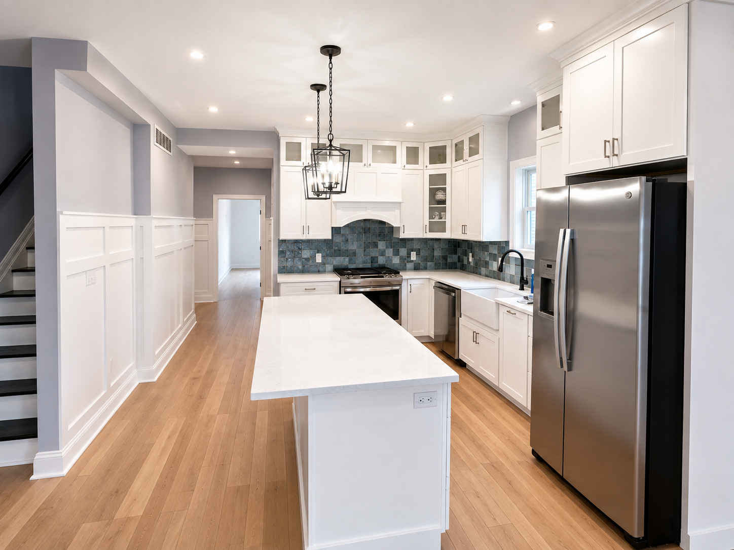 Finished kitchen installation with cabinetry, island, and trim