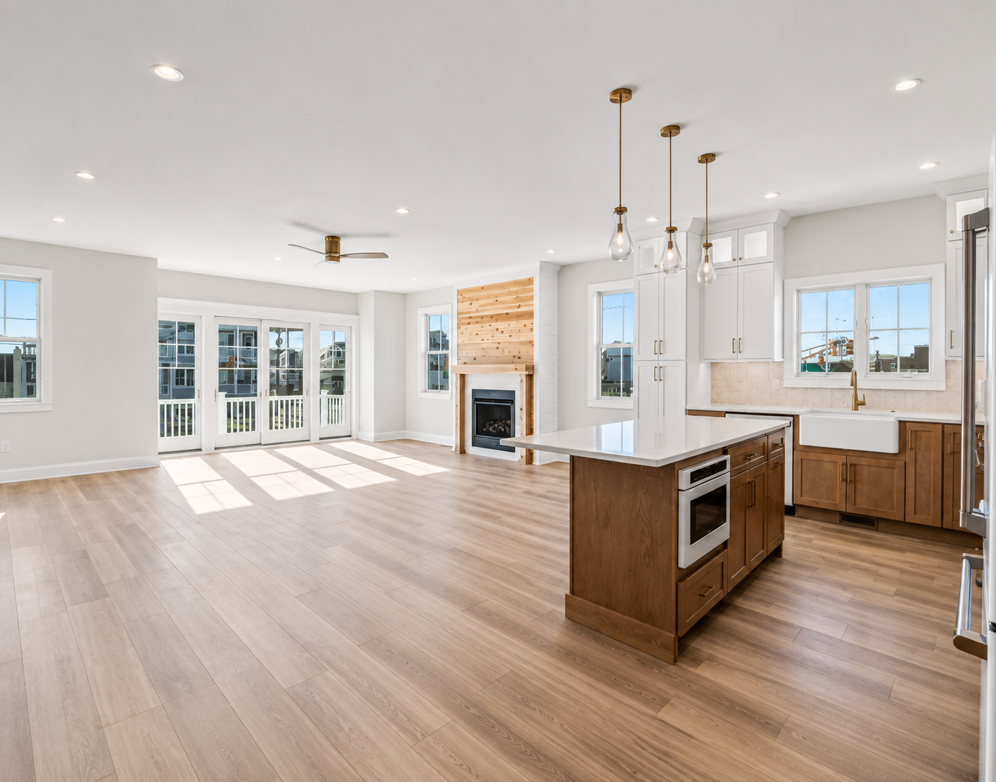 Finished open concept interior with kitchen, fireplace, trim, and ceiling details
