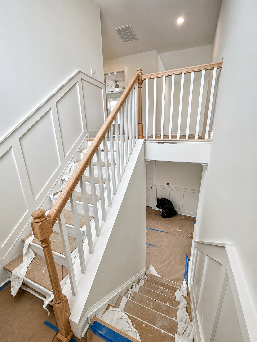 Completed staircase railing detail with finished wood handrail
